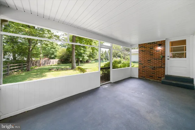 a view of an empty room with a balcony and swimming pool