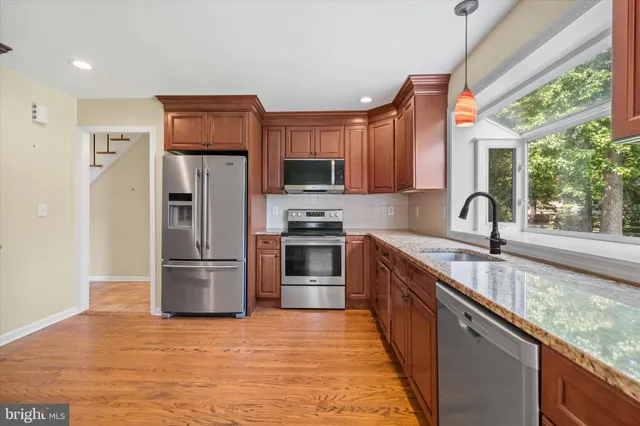 a kitchen with granite countertop a refrigerator and a sink