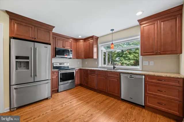 a kitchen with stainless steel appliances granite countertop a refrigerator sink and microwave