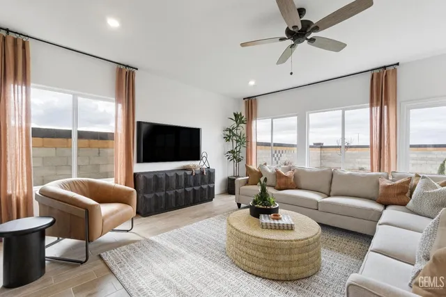 a living room with furniture a flat screen tv and a large window