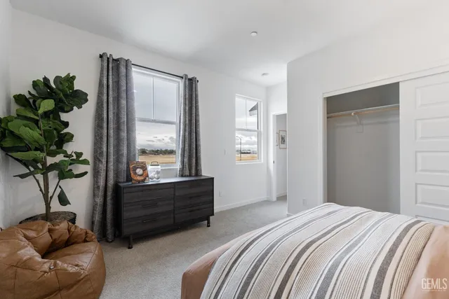 a bedroom with a bed and a potted plant