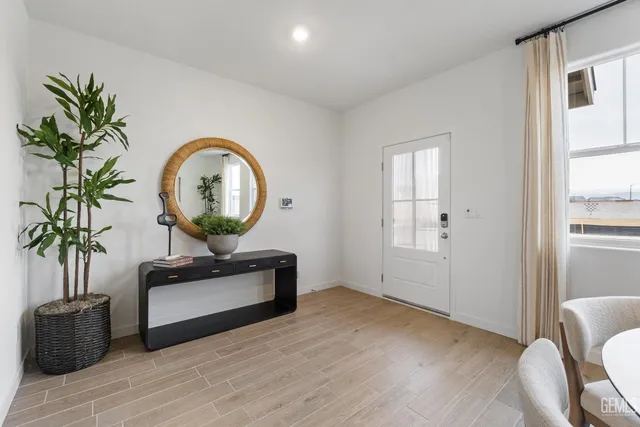 a living room with furniture a potted plant and a wooden floor