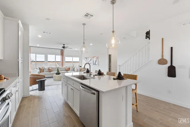 a kitchen with a sink a counter space appliances and cabinets