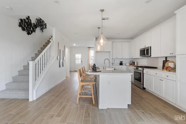 a kitchen with white cabinets and stainless steel appliances