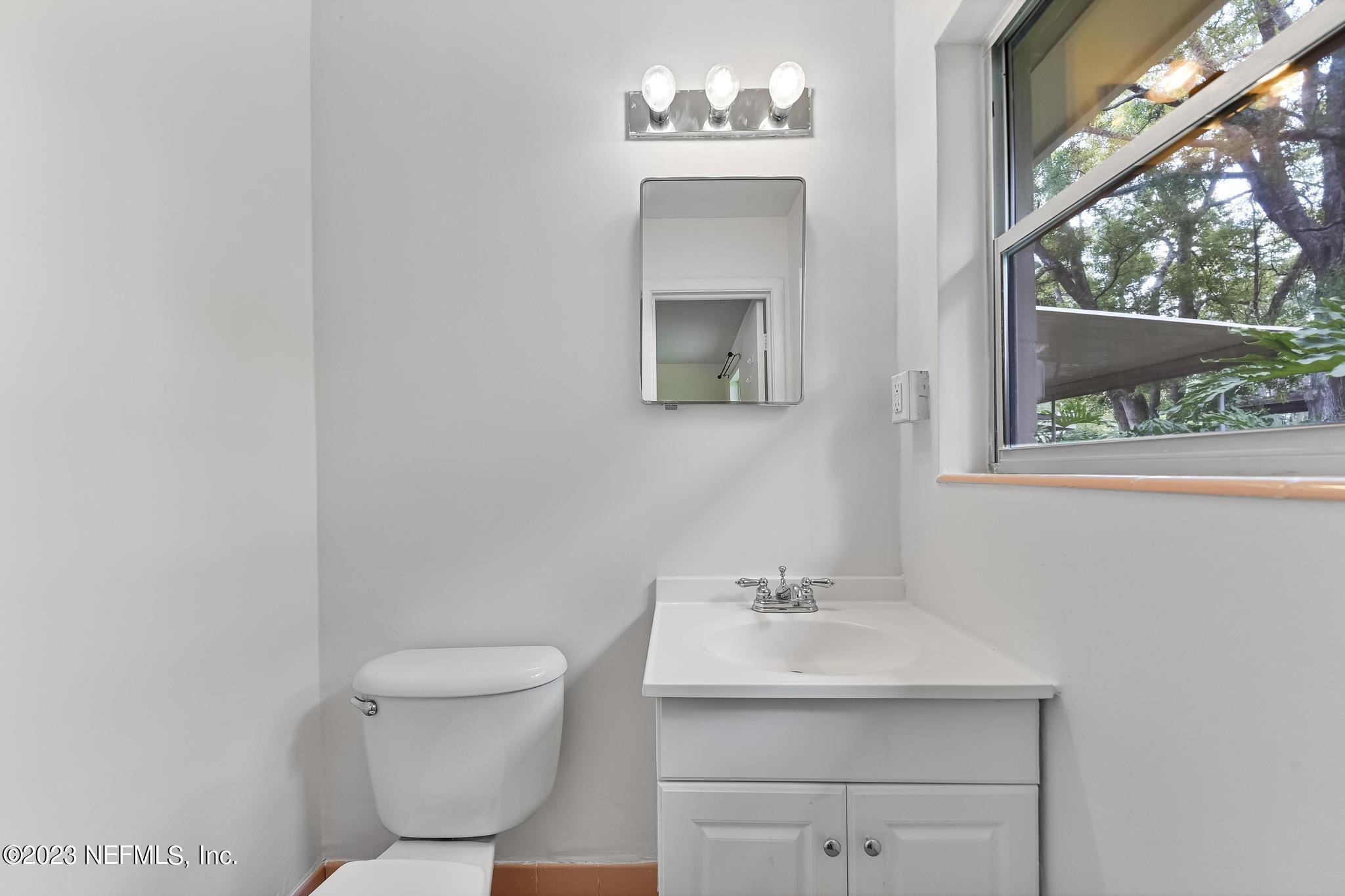 5627 Sabena Road Jacksonville, FL 32207 - Photo 15 of 22 a bathroom with a sink toilet and a window