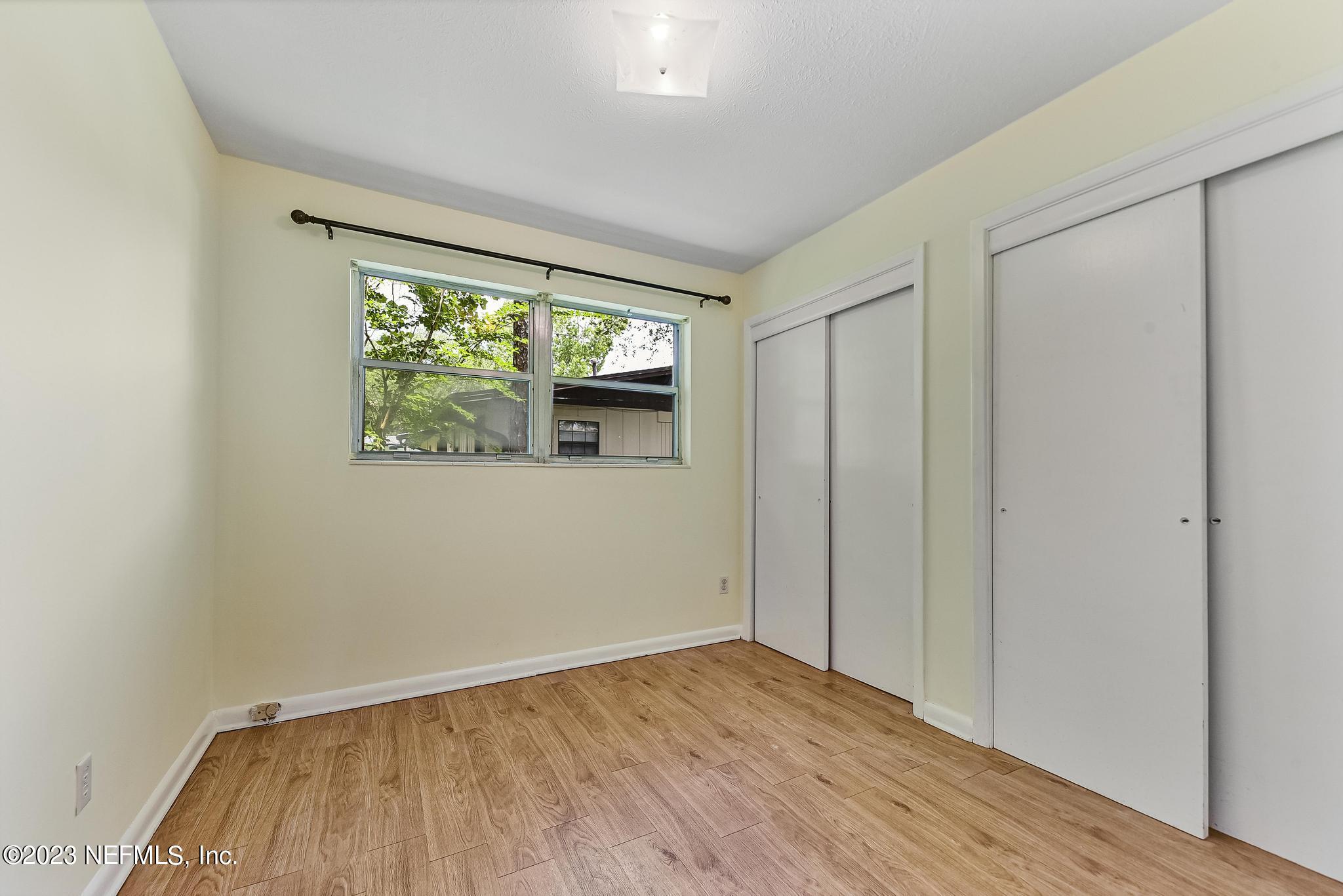5627 Sabena Road Jacksonville, FL 32207 - Photo 18 of 22 a view of an empty room with wooden floor and a window
