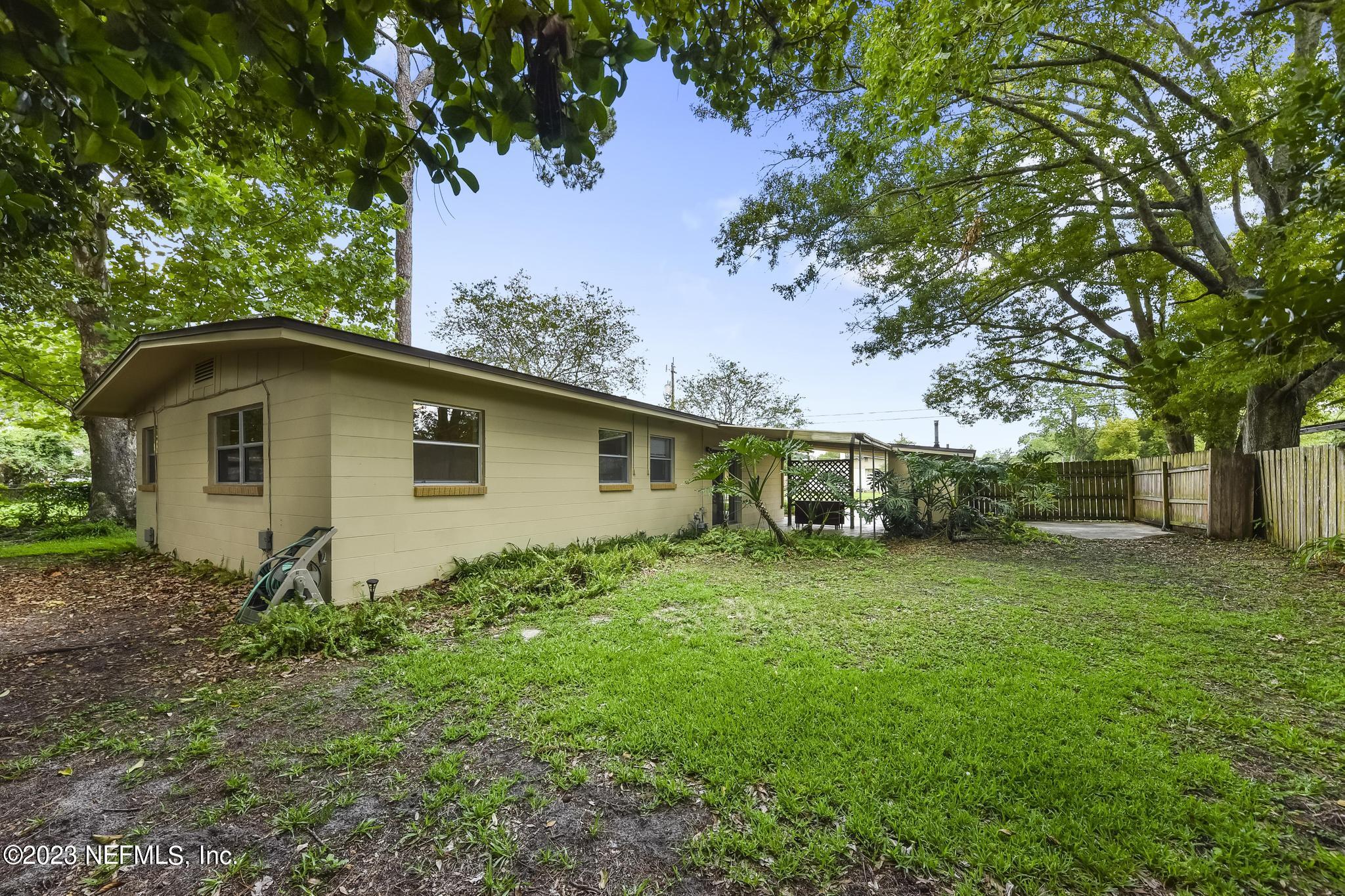 5627 Sabena Road Jacksonville, FL 32207 - Photo 21 of 22 a backyard of a house with plants and large tree
