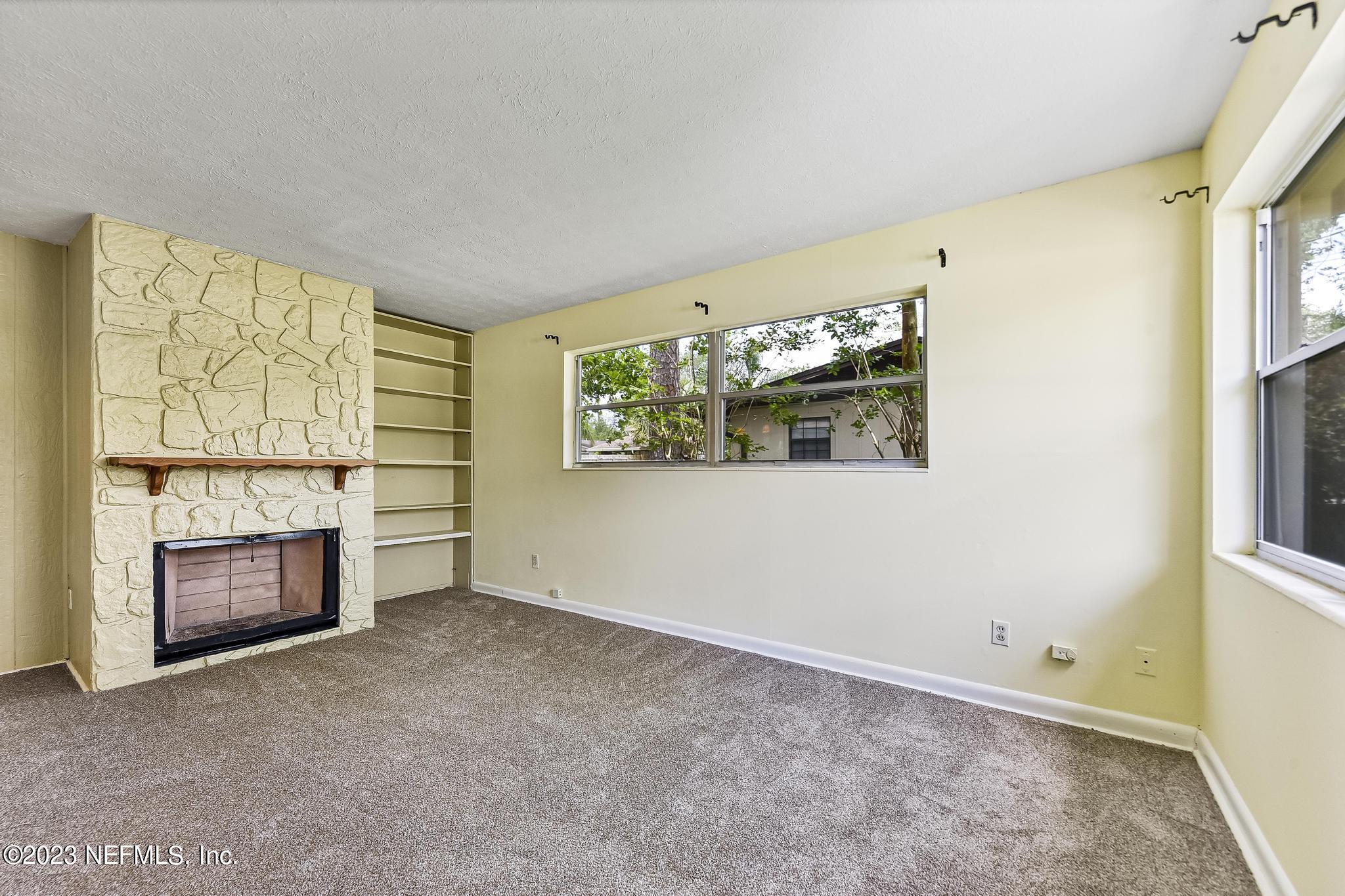 5627 Sabena Road Jacksonville, FL 32207 - Photo 5 of 22 a view of empty room with a fireplace and window
