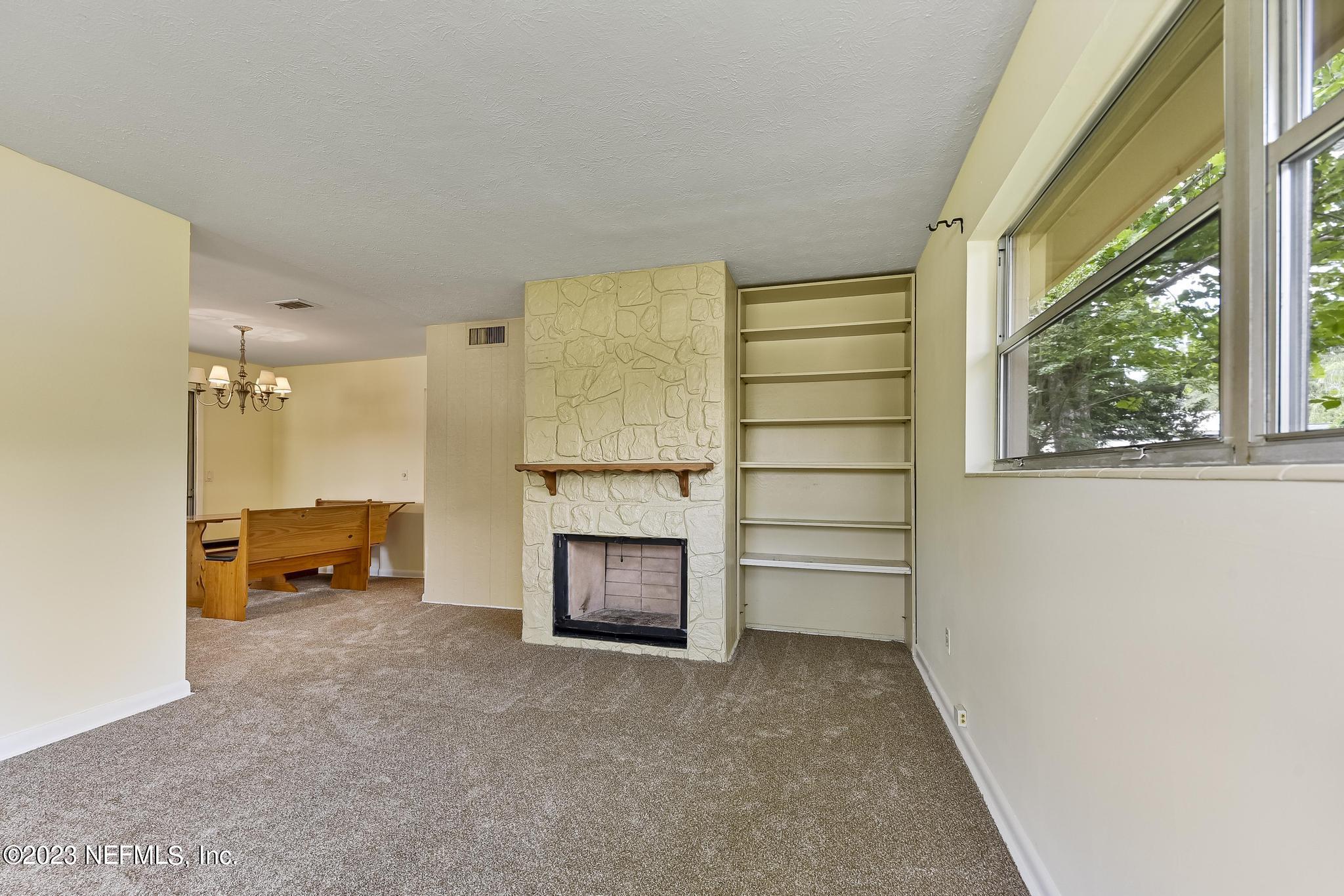 5627 Sabena Road Jacksonville, FL 32207 - Photo 6 of 22 an empty room with furniture and a fireplace