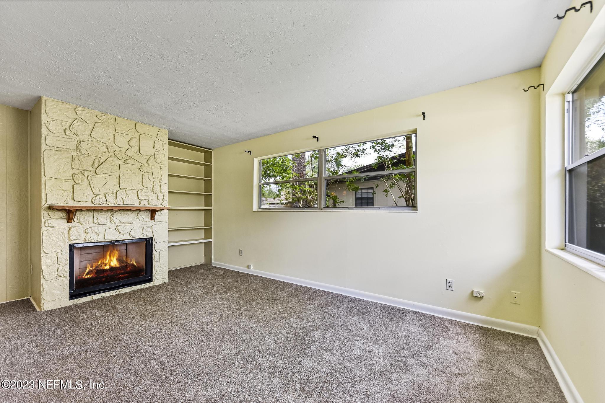 5627 Sabena Road Jacksonville, FL 32207 - Photo 7 of 22 a view of an empty room with a fireplace and a window