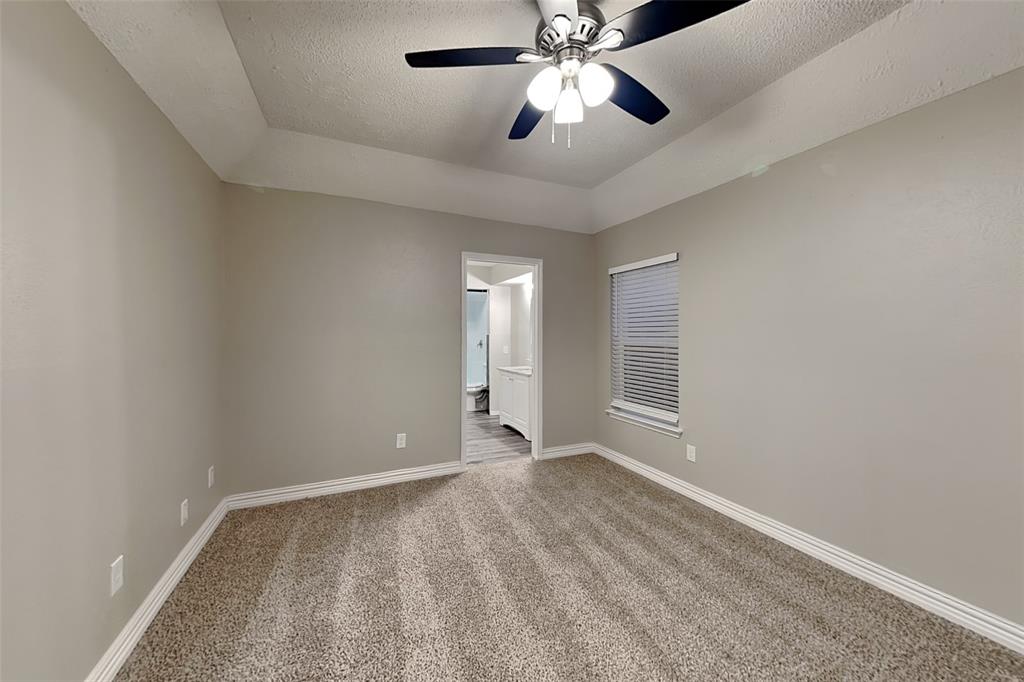 2730 Naples Drive Garland, TX 75040 - Photo 7 of 18 an empty room with a chandelier fan and windows