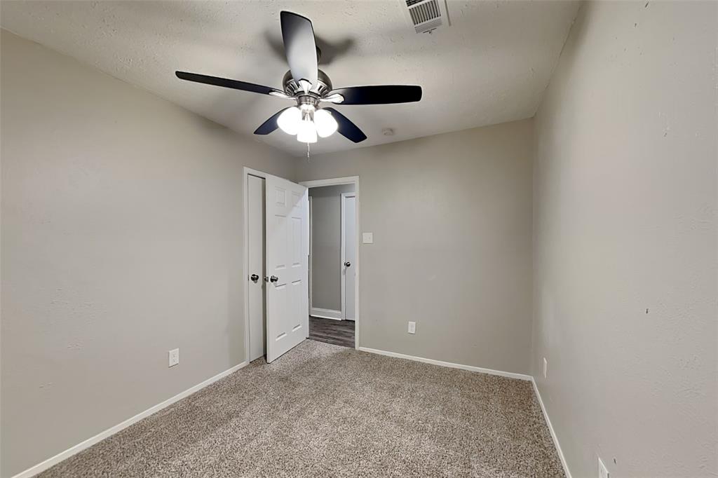 2730 Naples Drive Garland, TX 75040 - Photo 10 of 18 an empty room with a chandelier fan and windows