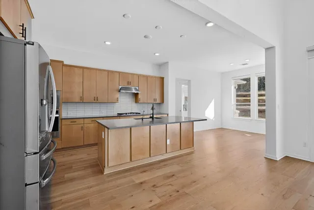 a kitchen with stainless steel appliances a refrigerator sink and cabinets