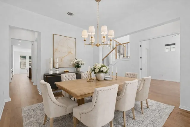 a kitchen with stainless steel appliances granite countertop a stove top oven a sink dishwasher and a refrigerator with wooden floor