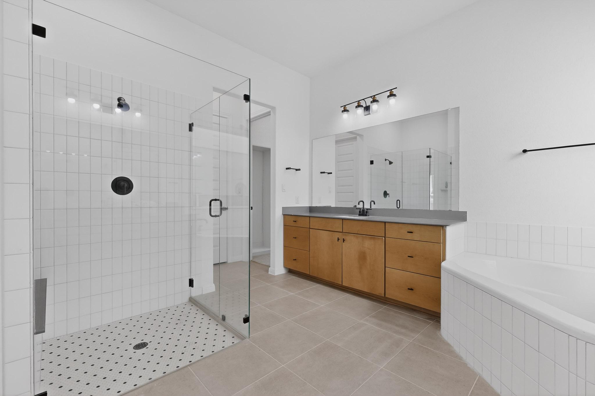 7705 Alouette Drive Austin, TX 78738 - Photo 18 of 40 a bathroom with a granite countertop sink a mirror a shower and a bathtub
