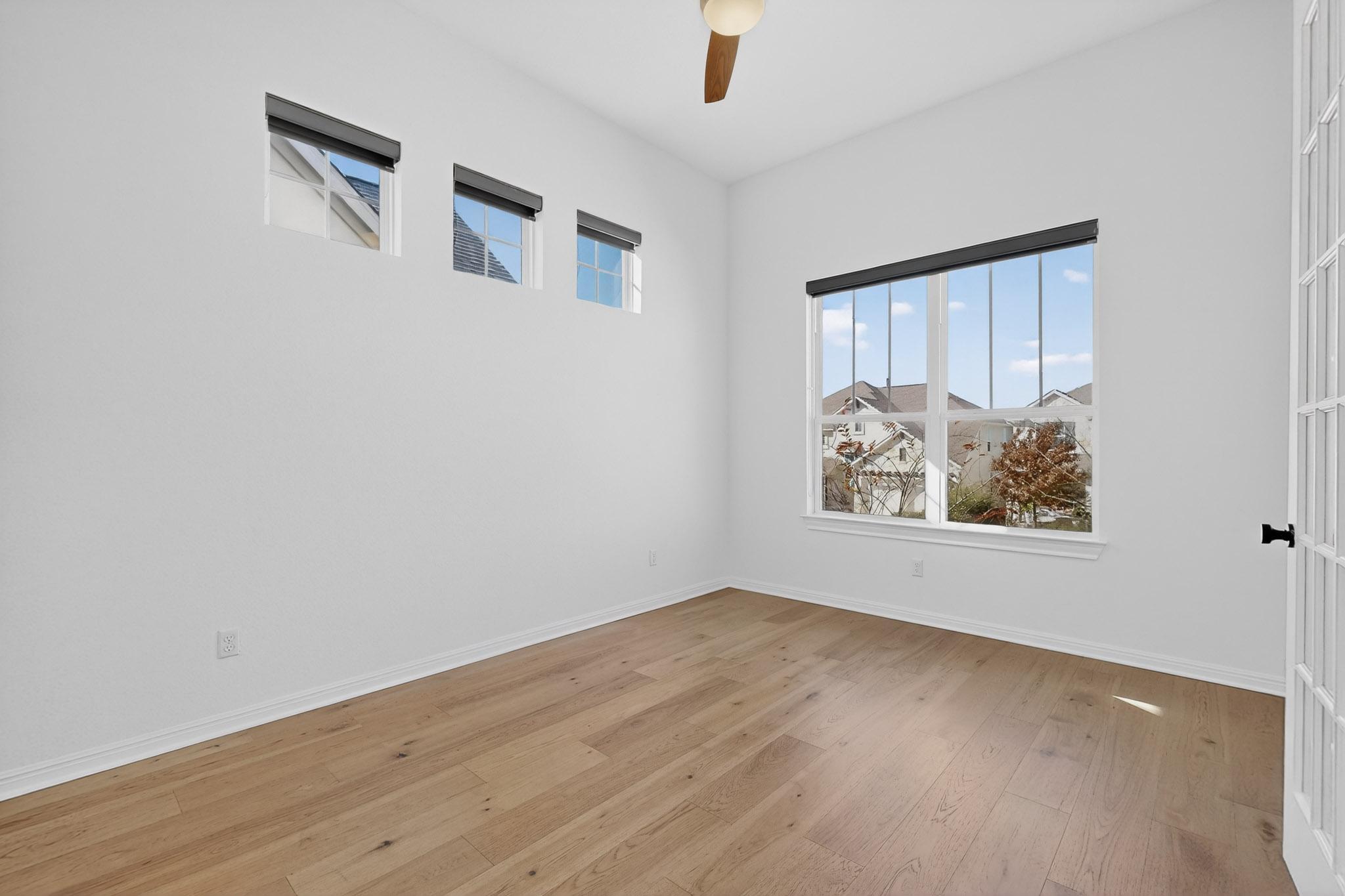 7705 Alouette Drive Austin, TX 78738 - Photo 21 of 40 a view of an empty room with wooden floor and a window