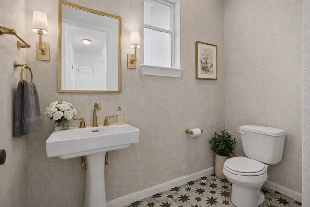 a bathroom with a toilet sink and mirror