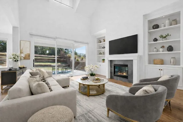 a living room with furniture a fireplace and a flat screen tv
