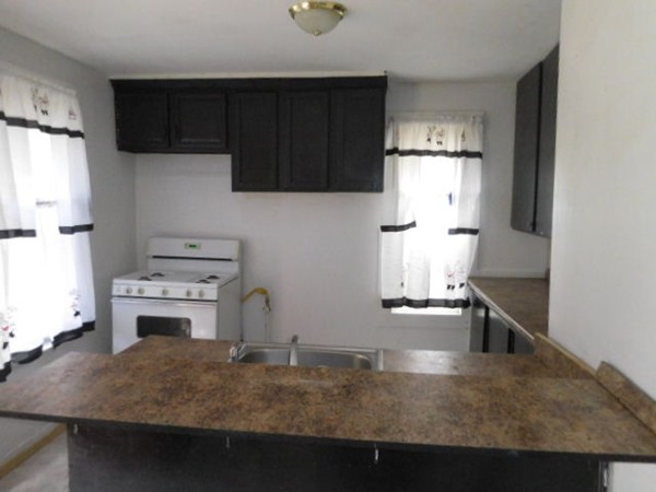 63 Oak Street Springfield, MA 01151 - Photo 4 of 10 a kitchen with kitchen island a stove a refrigerator and a sink
