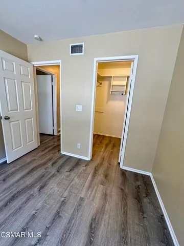 an empty room with wooden floor and closet