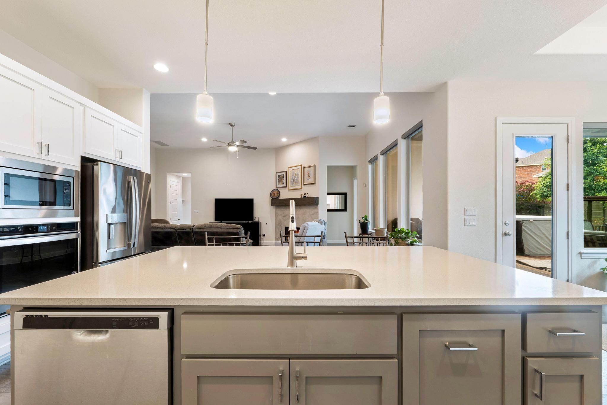1009 Legacy Crossing Georgetown, TX 78628 - Photo 14 of 40 Sleek island kitchen with integrated stainless steel appliances and an open view to the living area.