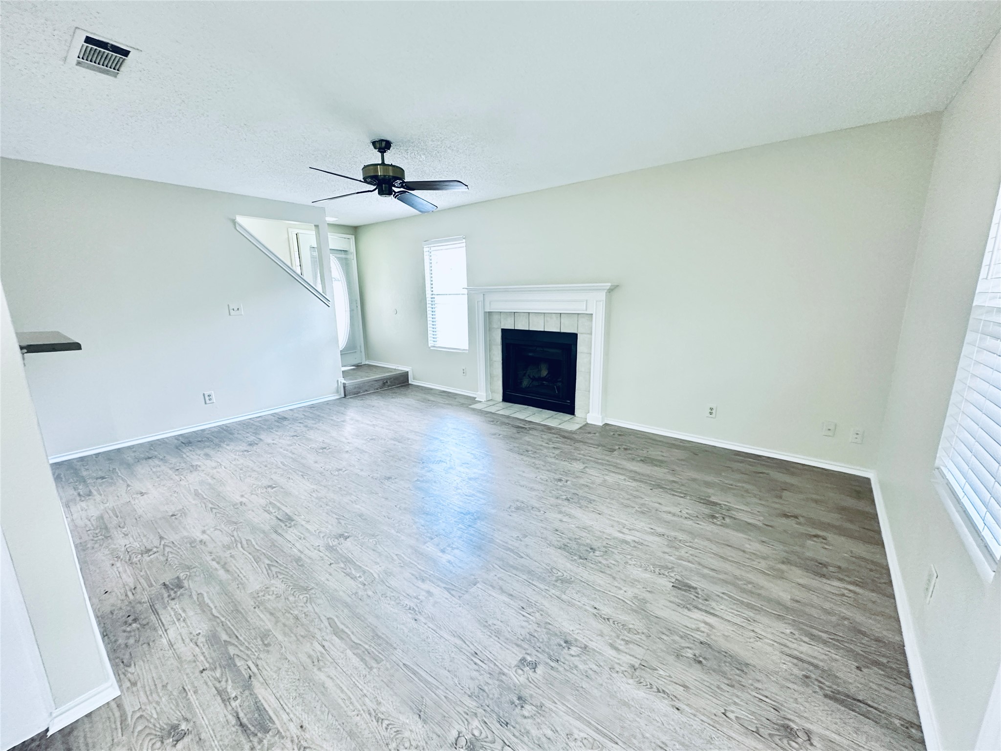 379 Fantail Loop, Unit B Austin, TX 78734 - Photo 9 of 33 A classic fireplace Anchors the spacious living area featuring wood-look flooring and clean walls.