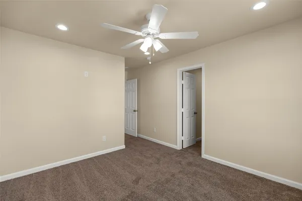 an empty room with a ceiling fan and a window