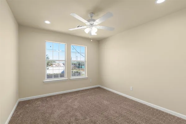 an empty room with a window and a fan