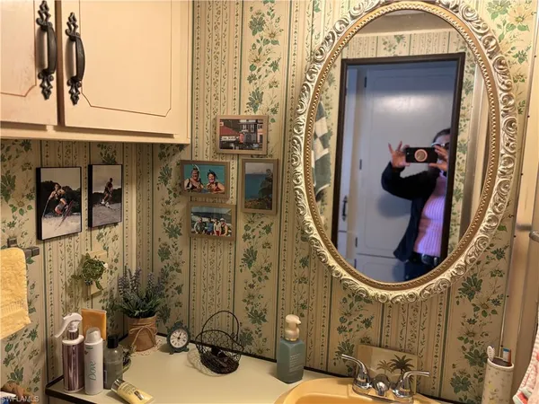 a bathroom with a sink and mirror with bathtub