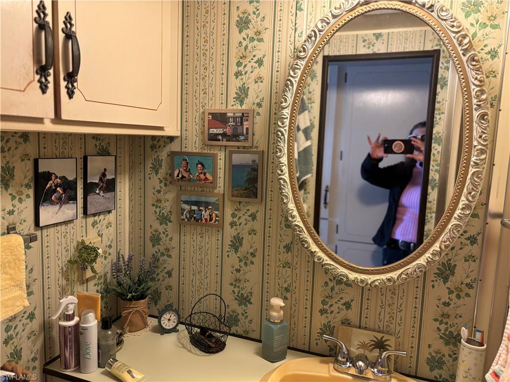 9 Jade Drive, Unit 9J Naples, FL 34114 - Photo 17 of 28 a bathroom with a sink and mirror