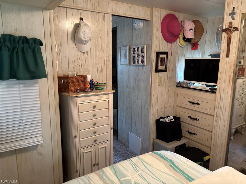 9 Jade Drive, Unit 9J Naples, FL 34114 - Photo 20 of 28 a bedroom with a bed and a flat tv screen