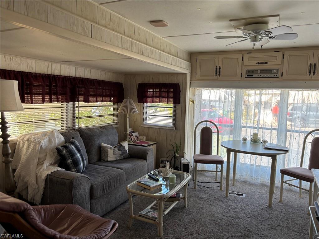 9 Jade Drive, Unit 9J Naples, FL 34114 - Photo 22 of 28 a living room with furniture a fireplace and a floor to ceiling window