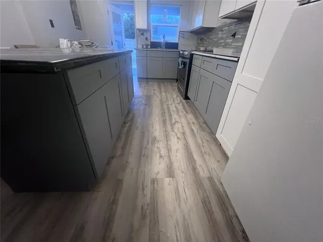 a kitchen with a sink and wooden floor