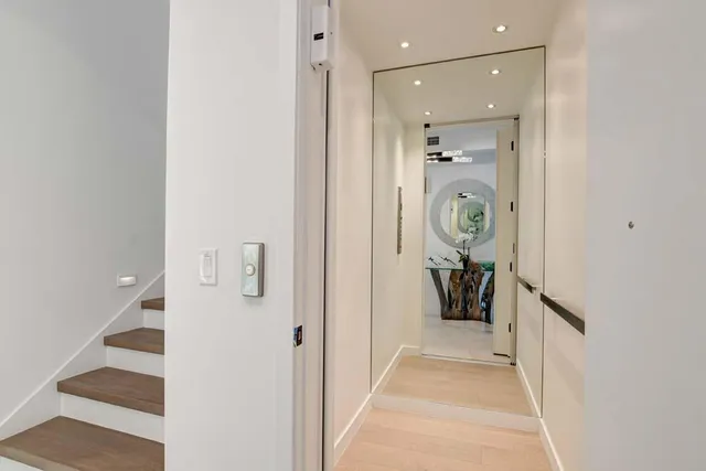a living room with furniture floor to ceiling window hardwood floor and a flat screen tv