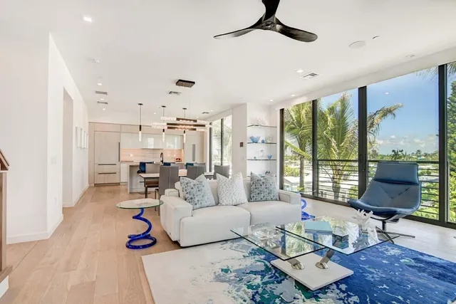 a kitchen with stainless steel appliances granite countertop a stove a refrigerator a sink a dining table and chairs with wooden floor