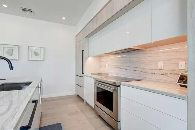 a kitchen with stainless steel appliances granite countertop a sink and refrigerator