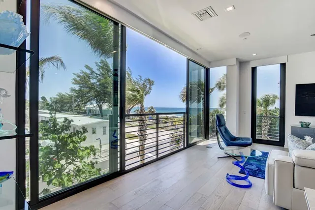 a view of a hallway with wooden floor and windows