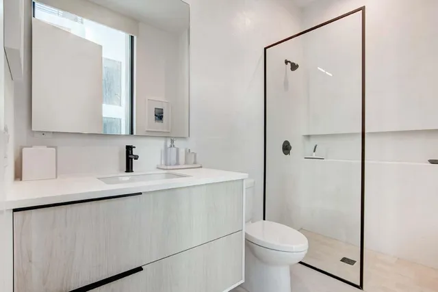 a bedroom with a bed chandelier and a window