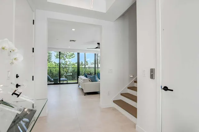 a living room with furniture a flat screen tv and a large window
