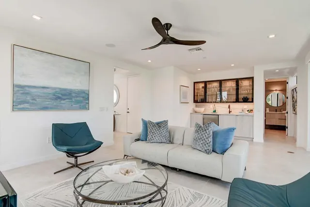 a large white kitchen with sink and large window