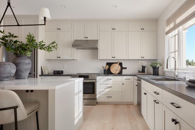 a kitchen with kitchen island white cabinets and white appliances