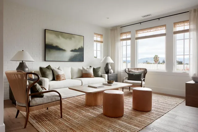 a living room with furniture a large window and a table