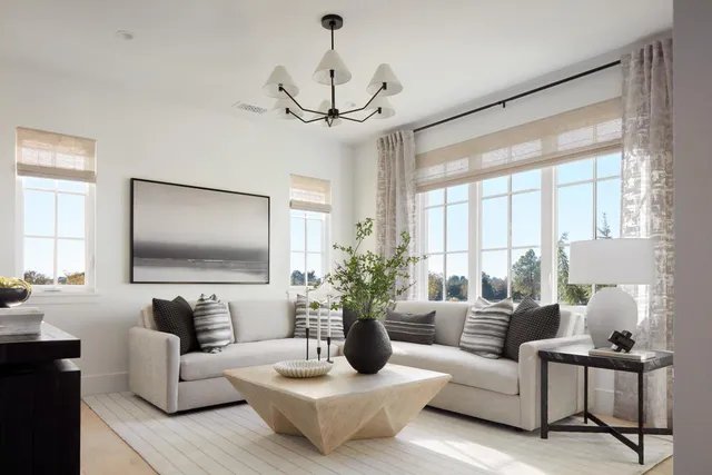 a living room with furniture a large window and a chandelier