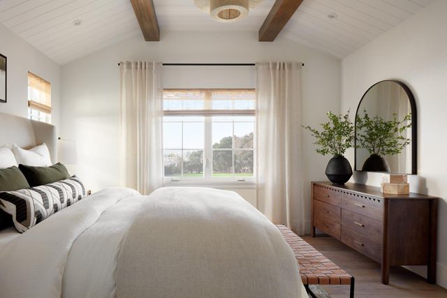 a bedroom with a large bed and a potted plant