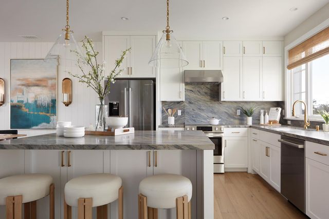 a kitchen with stainless steel appliances granite countertop a white cabinets and a stove