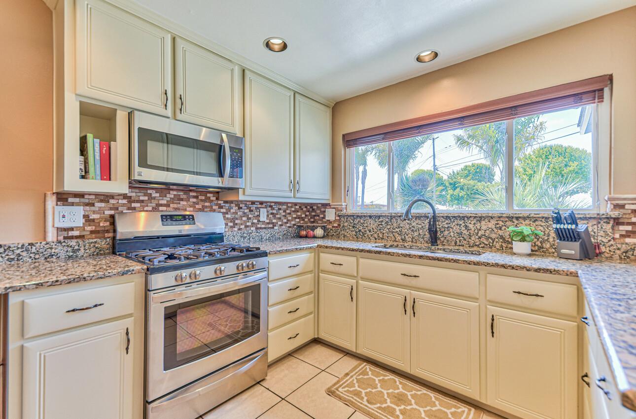 26 Young Drive Salinas, CA 93901 - Photo 11 of 28 a kitchen with stainless steel appliances granite countertop a stove a sink and white cabinets