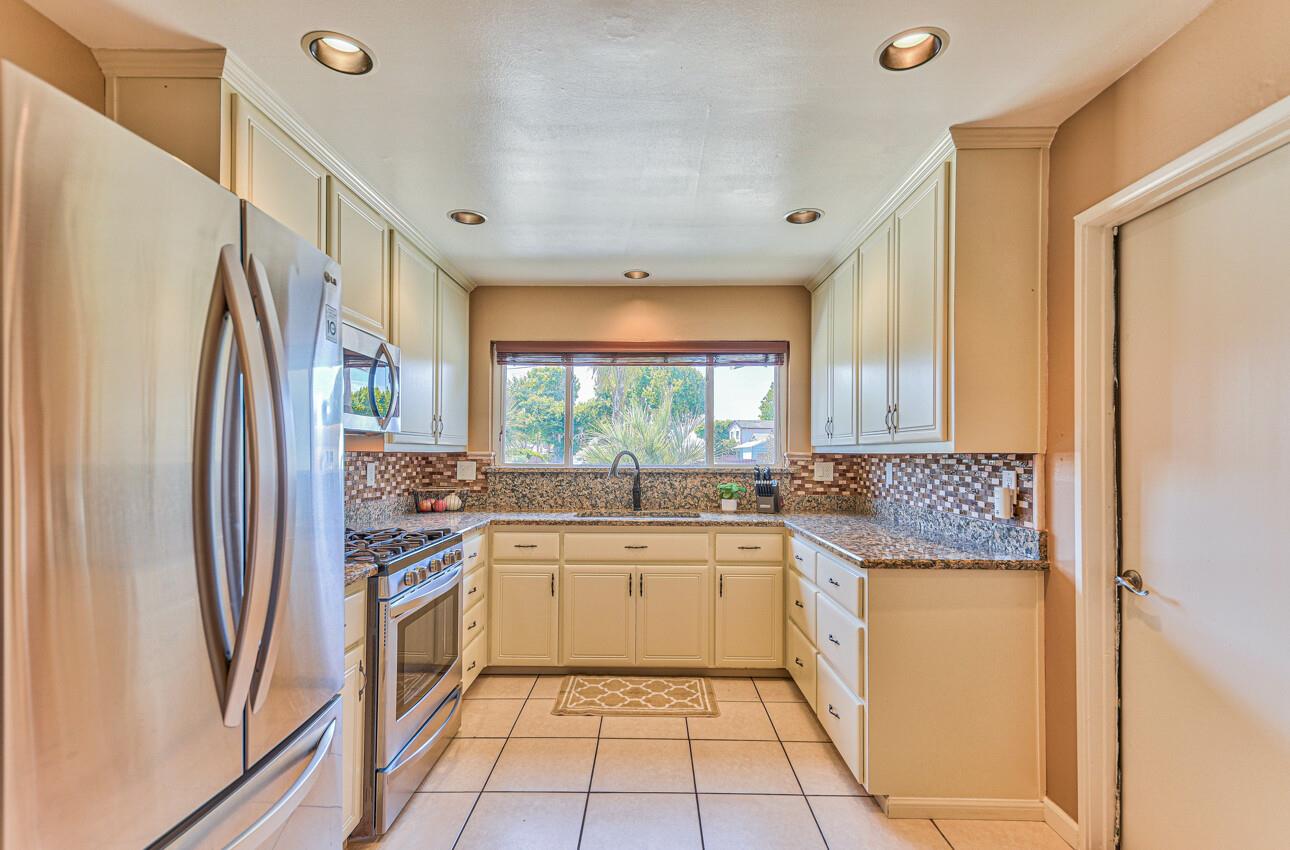 26 Young Drive Salinas, CA 93901 - Photo 10 of 28 a kitchen with stainless steel appliances granite countertop a refrigerator a sink dishwasher a stove with white cabinets and wooden floor