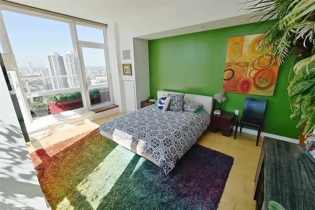 a bed sitting in a bedroom next to a window