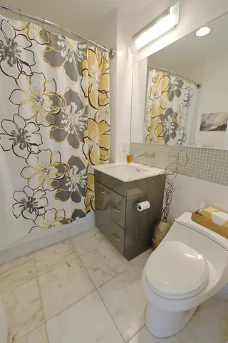 a bathroom with a toilet sink and mirror