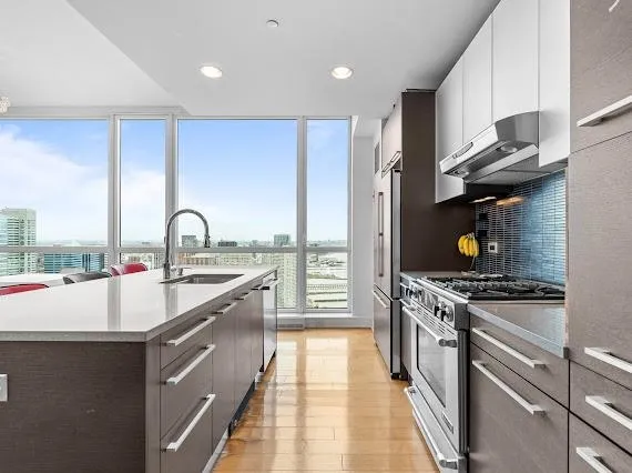 a kitchen with stainless steel appliances a sink stove and cabinets